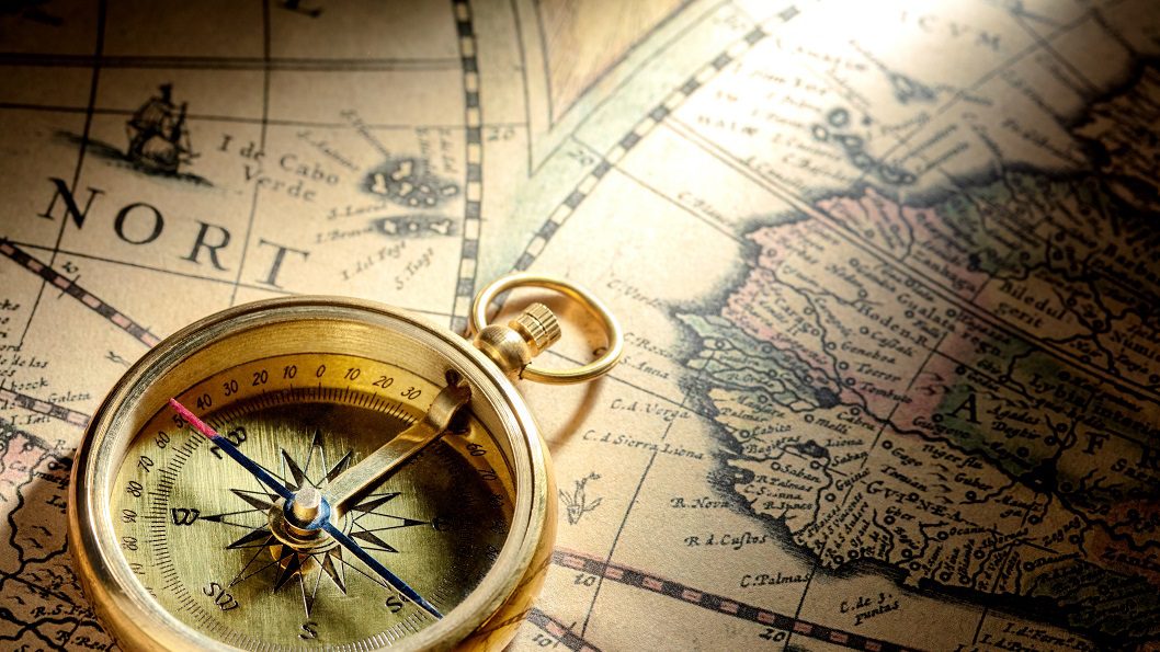 Antique compass on ancient map