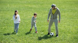 children-playing-soccer-with-father-in-park-2021-09-08-20-55-17-utc-scaled-e1634736781526