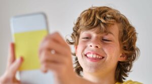 content-boy-taking-selfie-on-smartphone-on-light-b-2021-10-21-02-30-53-utc-scaled-e1636287598494
