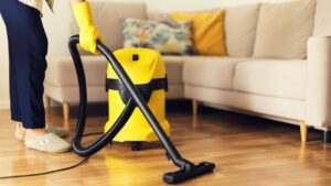 woman-cleaning-sofa-with-yellow-vacuum-cleaner-cop-MJAU3X2-e1616312252827