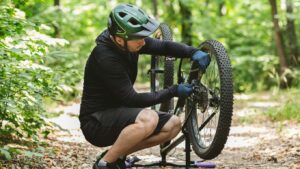 young-bicyclist-fixing-bike-chain-in-forest-Q9USB2F-e1615550969243